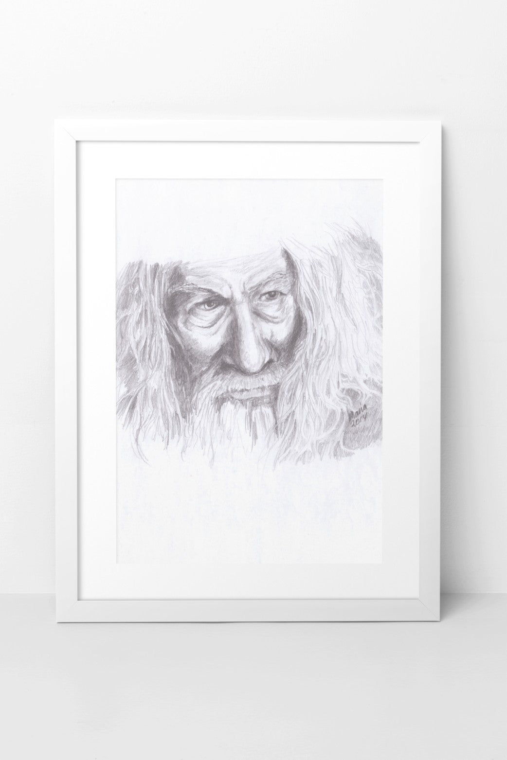 Pencil drawing of Ian McKellen as Gandalf from The Lord of the Rings, depicted in grayscale. The artwork features a close-up of his face and thick hair, capturing the character's detailed and expressive features. The A4-sized artwork is displayed in a white mock-up frame against a neutral background, emphasizing its intricate detail and classic grayscale tones.