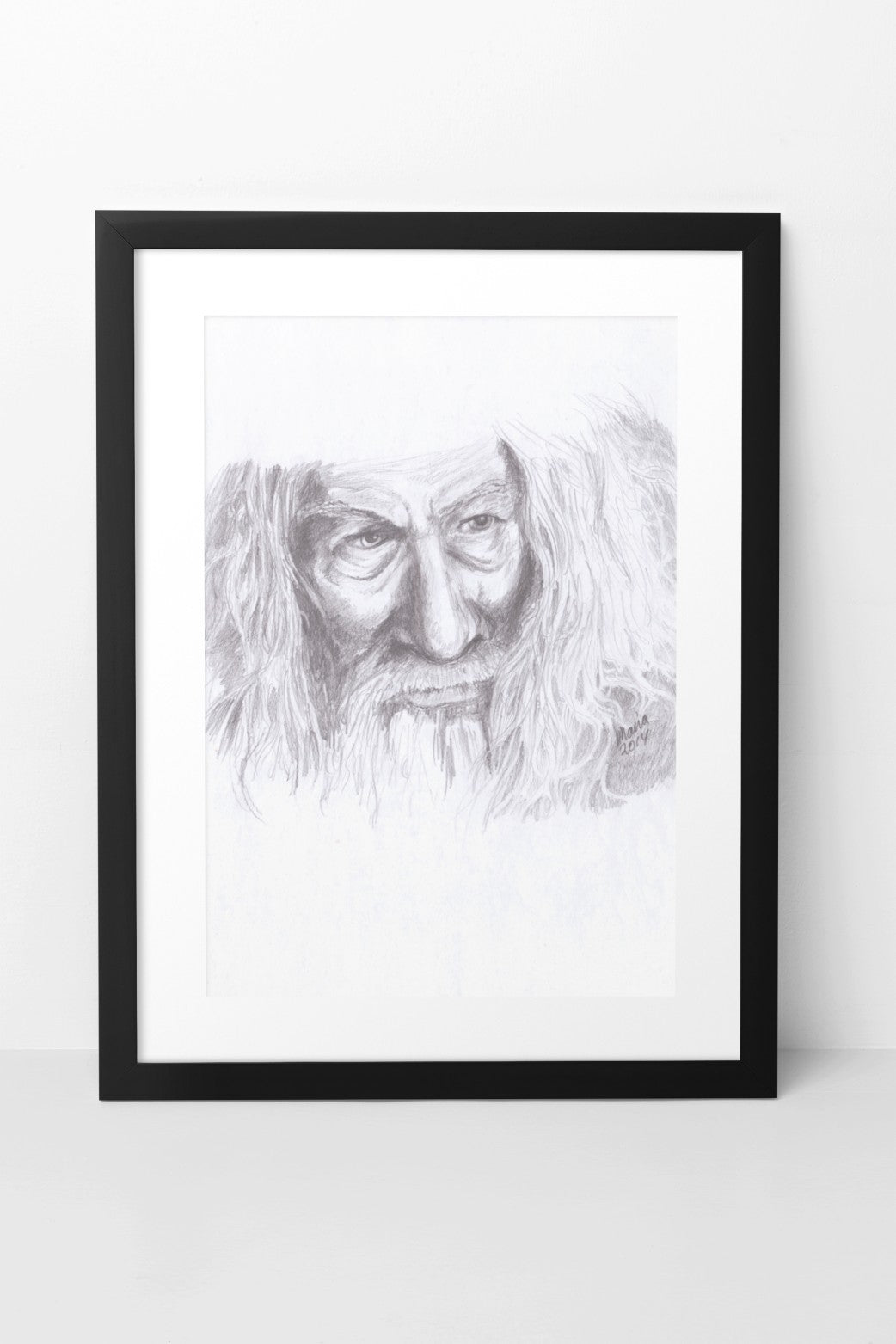 Pencil drawing of Ian McKellen as Gandalf from The Lord of the Rings, depicted in grayscale. The artwork features a close-up of his face and thick hair, capturing the character's detailed and expressive features. The A4-sized artwork is displayed in a black mock-up frame against a neutral background, emphasizing its intricate detail and classic grayscale tones.