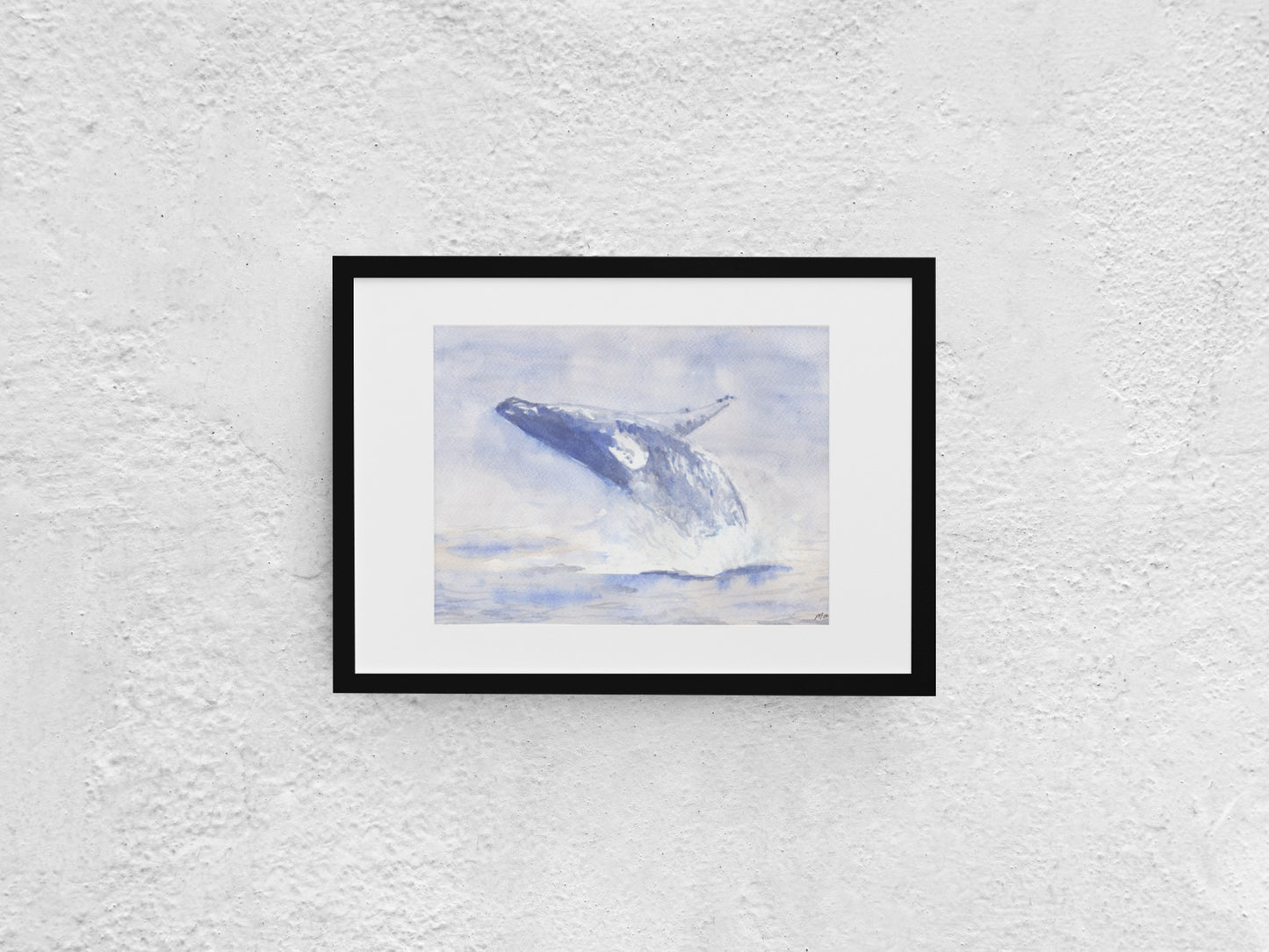 Watercolor painting of a blue whale jumping out of the water, positioned midway with its head toward the sea and belly toward the air. The artwork features soft blue hues contrasting against white, with visible water splashing. The A4-sized artwork is displayed in a black mock-up frame against a neutral background, emphasizing its soft colors and dynamic motion.