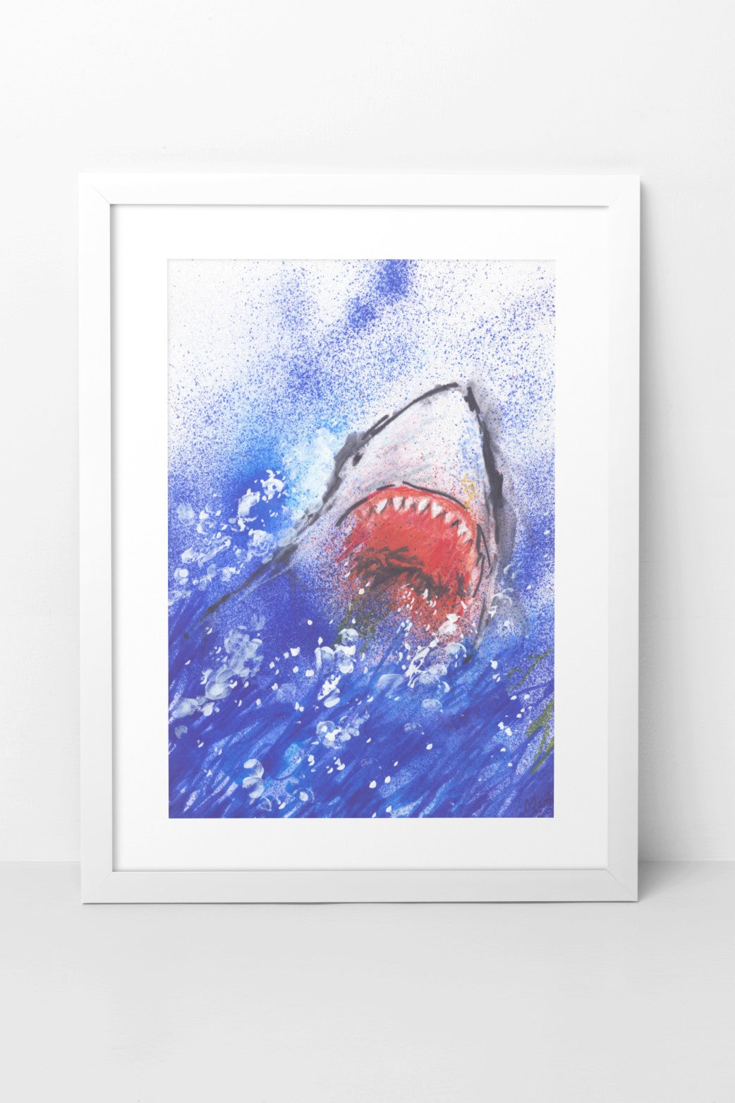 Pen drawing on glossy paper of a shark leaping out of deep blue waters with white splashes. The shark is shown from the front, with its gaping mouth and sharp teeth prominently visible. The A4-sized artwork is displayed in a white mock-up frame against a neutral background, highlighting the dynamic energy and sharp detail of the piece.
