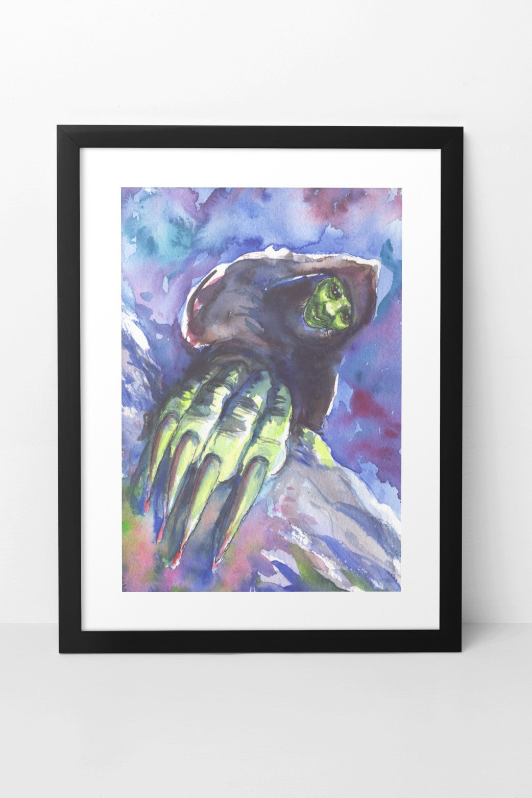 Watercolor painting of Grýla shown up close, with her hand featuring large claws even closer, as if she is climbing up toward the viewer. Her shadowy figure is contrasted by her green face and hand, which are highlighted. Grýla has a nefarious smile on her face. The background is filled with contrasting white, blue, and purple tones that stand out against the green and black elements of her figure. The A4-sized artwork is displayed in a black mock-up frame against a neutral background.