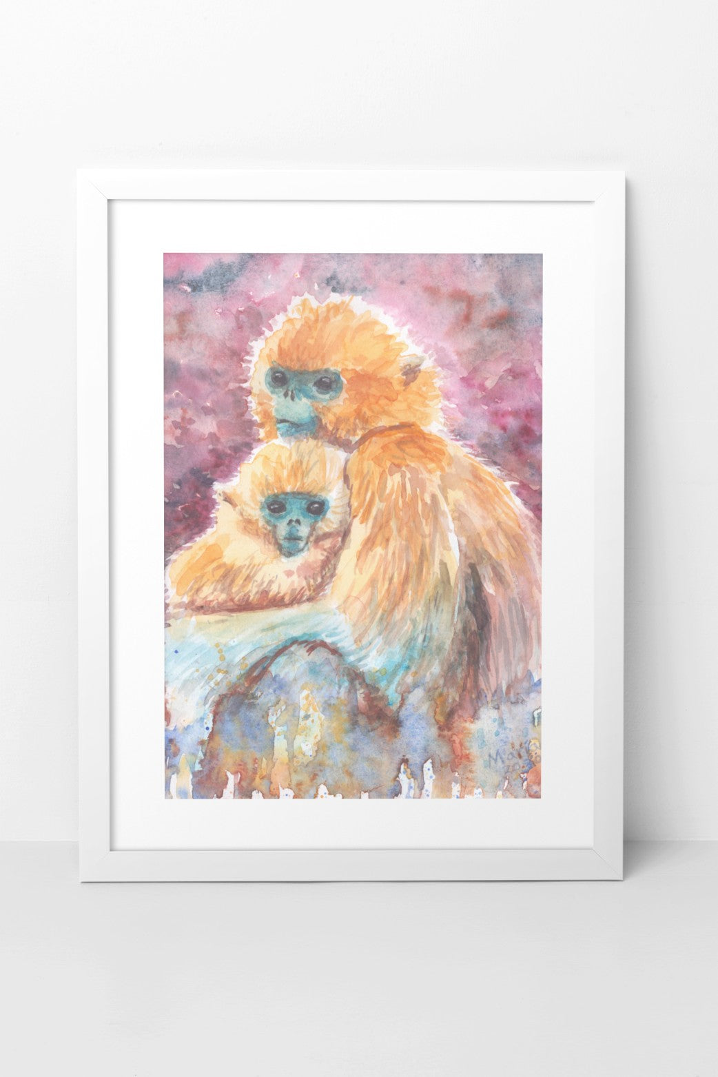 Watercolor painting of a golden snub-nosed monkey mother caressing her baby. The piece is vibrant, showcasing their golden fur, blue faces, deep dark eyes, and subtle smiles. The background features fluid red and black hues at the top, transitioning to green, blue, and brown at the bottom. Titled 'Happy Mother's Day,' the artwork celebrates all types of mothers in the world. The A4-sized artwork is displayed in a white mock-up frame against a neutral background, highlighting its rich colors & tender nature