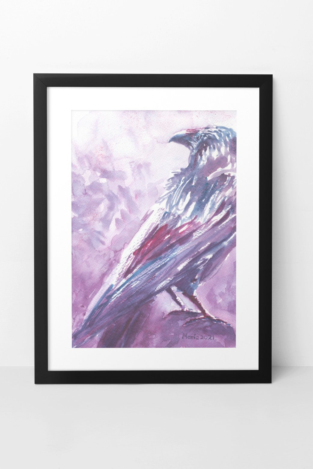 Watercolor painting of a raven resting on a perch, shown from the back with its head turned to the side. The A4-sized artwork is framed in a black mock-up frame against a white wall background. The raven is depicted in dark, soft shades of purple, red, and blue, adding a mysterious and contemplative mood to the piece.