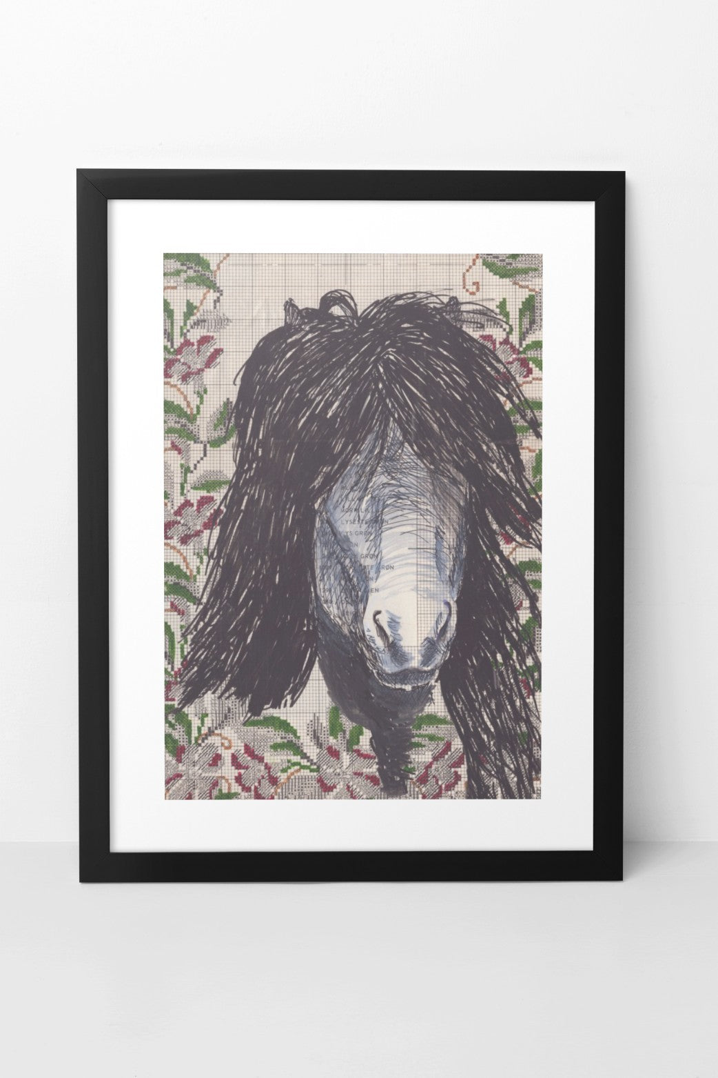 Mixed media artwork in collage and pen, featuring the face of an Icelandic horse with a luscious black mane, intricately drawn with pen. The background includes a printed textile pattern, adding texture and depth to the composition. The A4-sized artwork is displayed in a black mock-up frame against a neutral background, highlighting its detailed pen work and rich textures.
