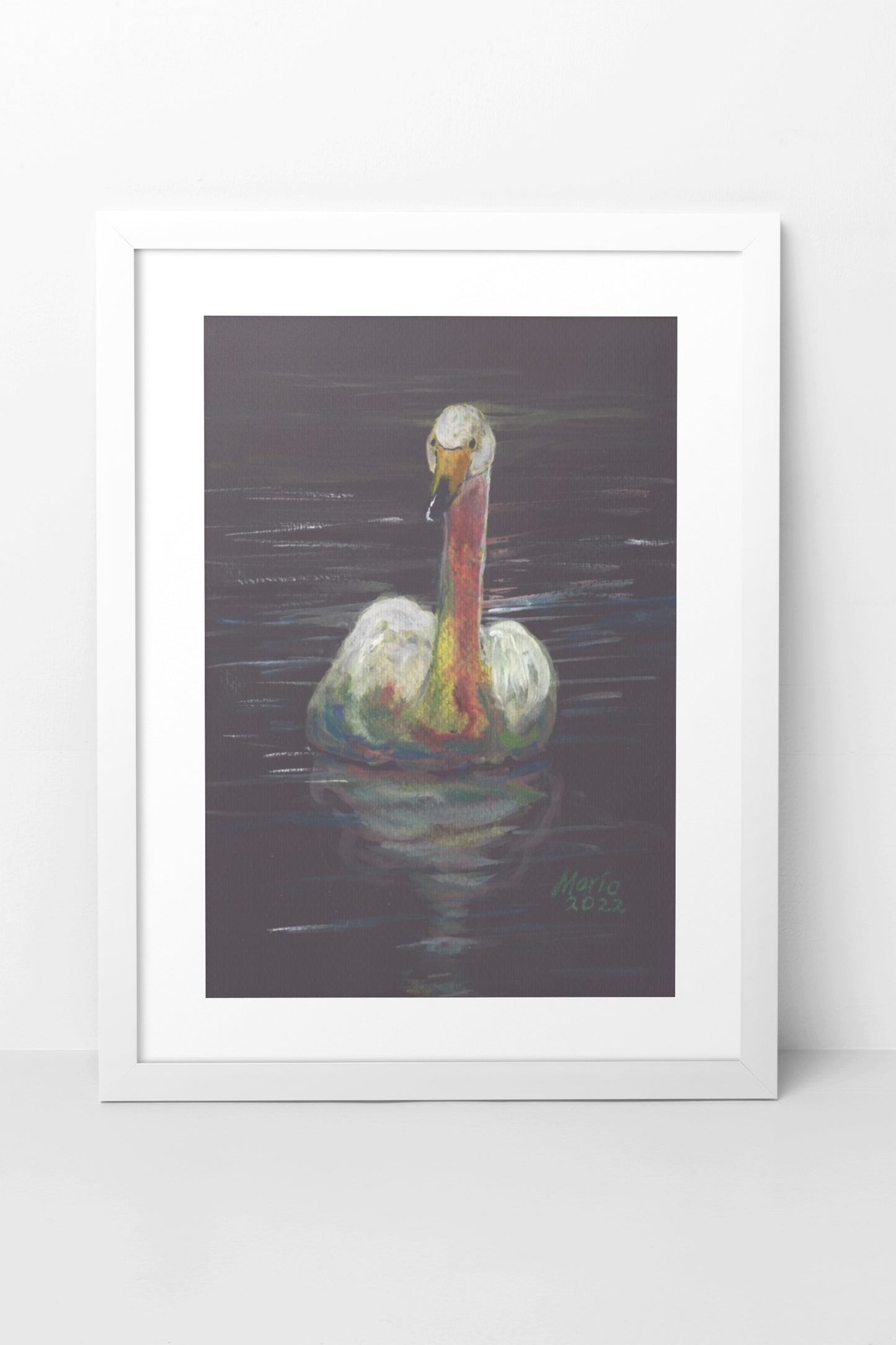 Gouache painting on black watercolor paper of a delicate white swan with an orange-tinted neck and a yellow and black beak. The swan is swimming in still water, with its reflection clearly visible. The A4-sized artwork is displayed in a white mock-up frame against a neutral background, highlighting the swan's delicate details and serene reflection.