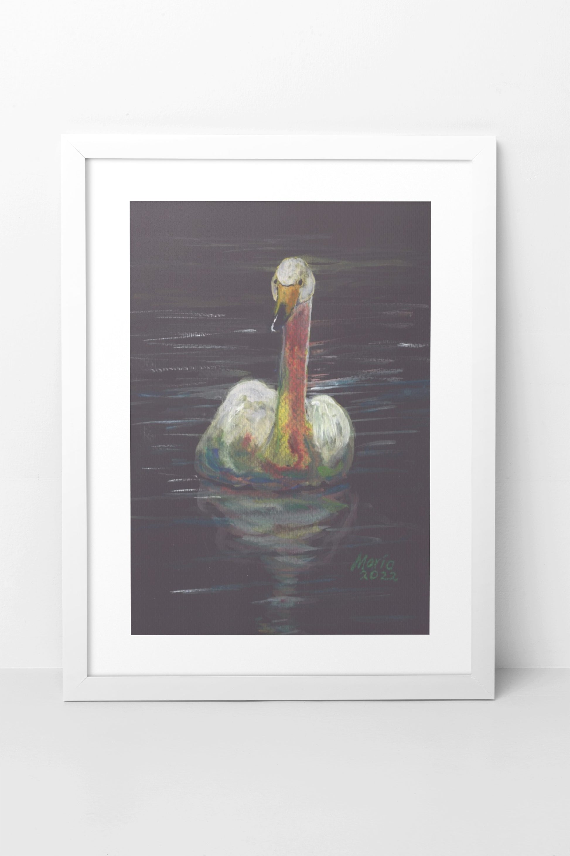 Gouache painting on black watercolor paper of a delicate white swan with an orange-tinted neck and a yellow and black beak. The swan is swimming in still water, with its reflection clearly visible. The A4-sized artwork is displayed in a white mock-up frame against a neutral background, highlighting the swan's delicate details and serene reflection.