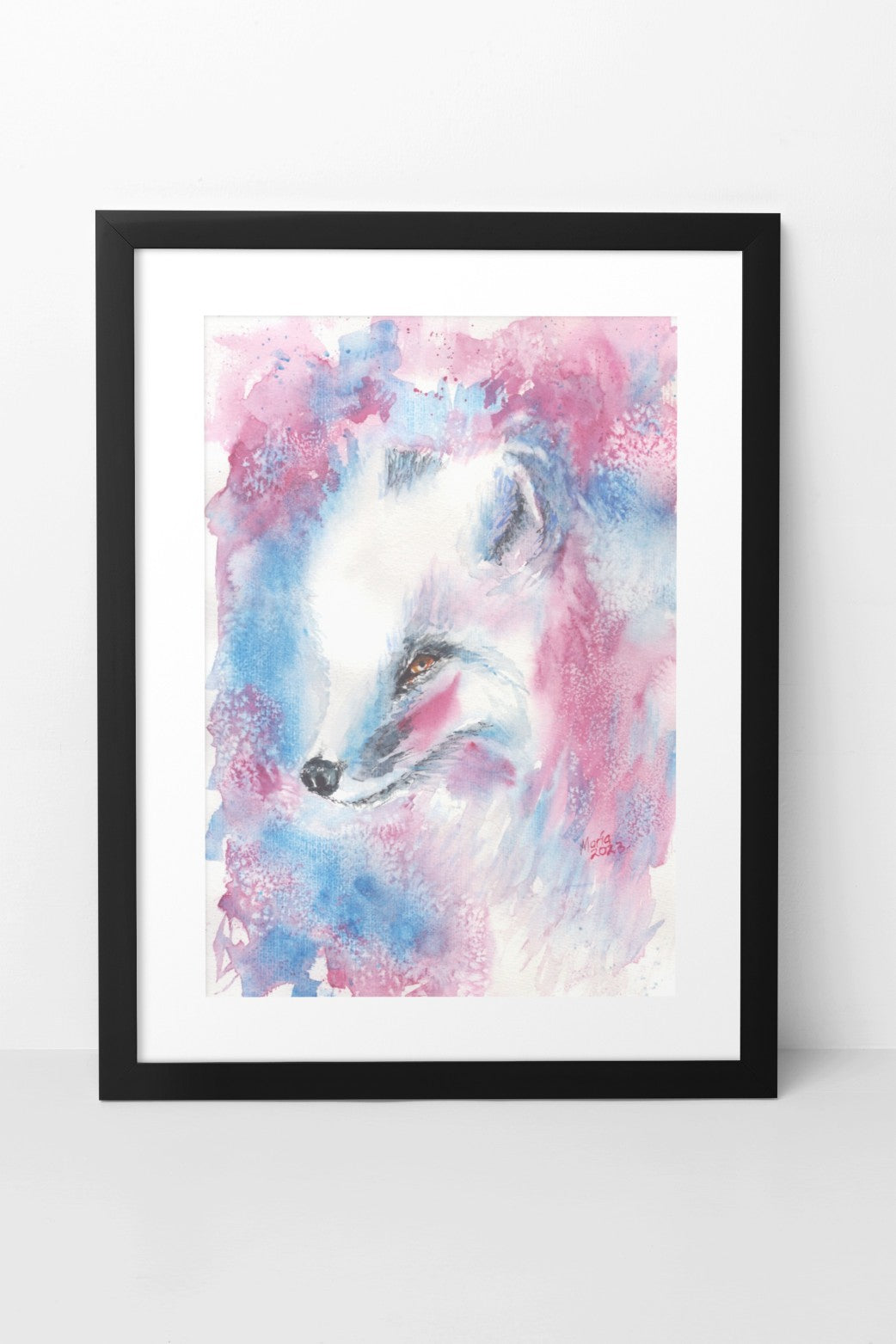 Watercolor painting of an Arctic fox, showing a close-up of its face as it looks to the left. The fox has fluffy white fur, brown eyes, a black nose, and a red brush stroke on its cheeks. The background features red, blue, and white hues. The slightly smaller-than-A3 artwork is displayed in a black mock-up frame against a neutral background, emphasizing the fox’s delicate features and vibrant colors.