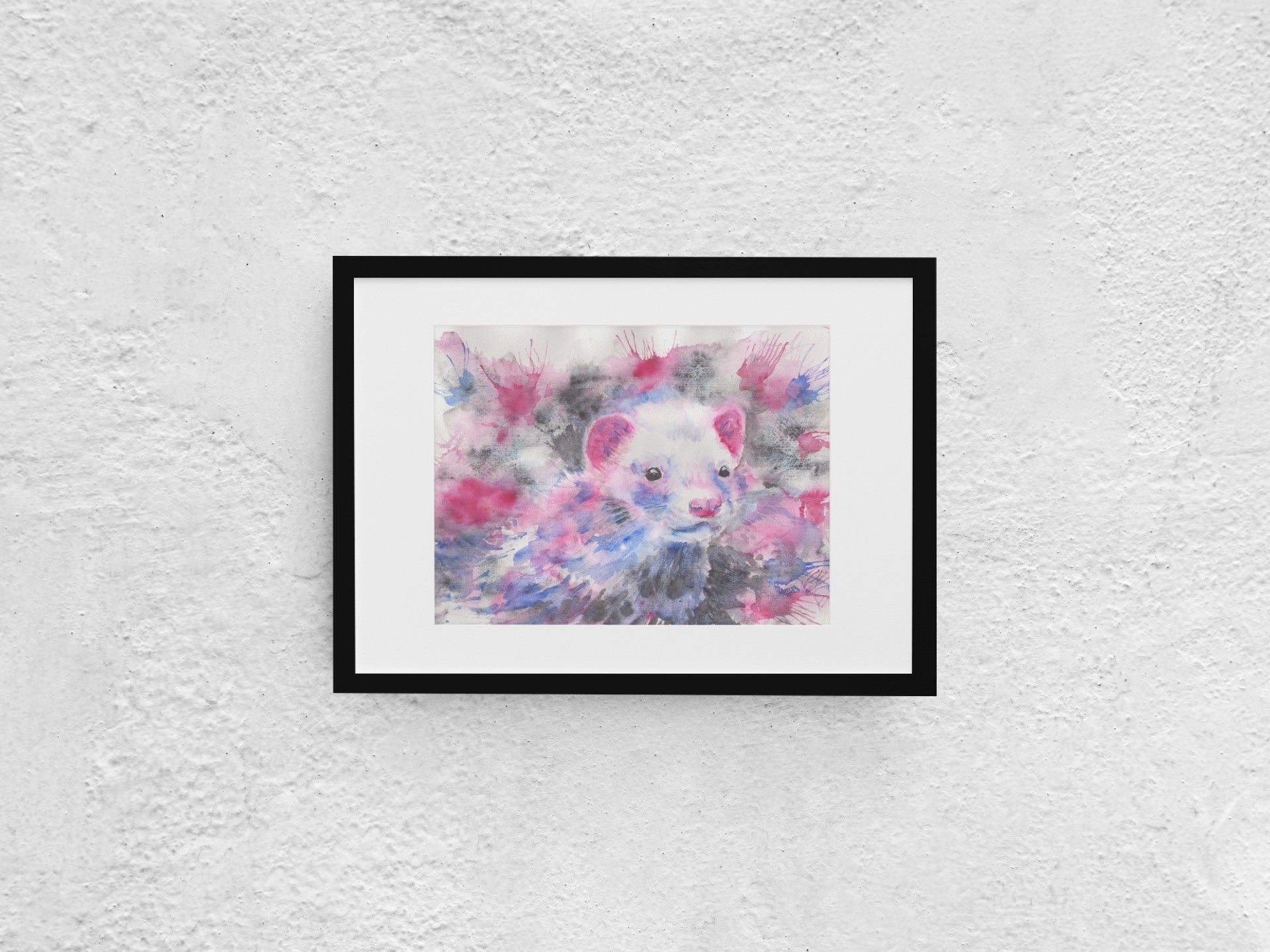 Watercolor painting of an American mink, shown up close, gazing to the right. The mink has white fur on its face, with pink ears, a pink nose, and black eyes. Its fur features hues of pinkish red, blue, and black, with touches of blue and pinkish red on its face. The background mirrors these colors with shades of blue, black, and red. The artwork, slightly smaller than A3, is displayed in a black mock-up frame against a neutral background, highlighting its vibrant colors and intricate detail.